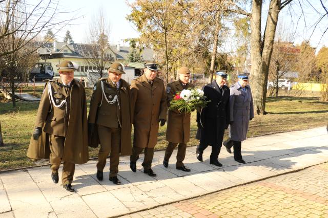 Delegacja służb mundurowych składa kwiaty pod pomnikiem