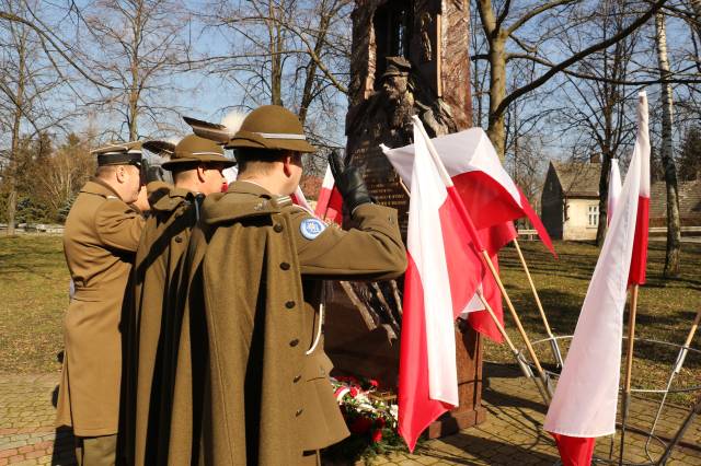 Delegacja służb mundurowych składa kwiaty pod pomnikiem