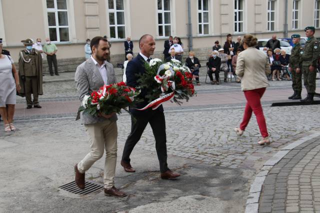 Składanie wiązanek kwiatów pod pomnikiem Bohaterów II wojny światowej - Mariusz Trojak, wicestarosta jarosławski oraz Marcin Malinowski, dyrektor biura senatorskiego Mieczysława Golby