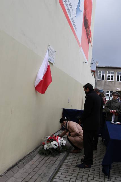 Złożenie wiązanek kwiatów pod odsłoniętym muralem przez społeczność szkolną