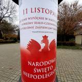 Słup ogłoszeniowy z okolicznościową grafiką z okazji 11 listopada.