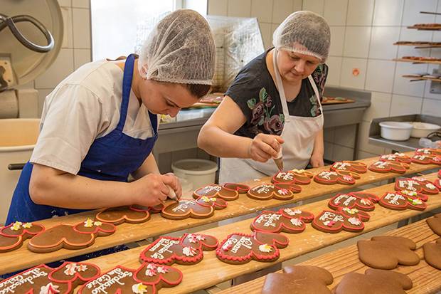 Pracownicy Wytwórni Wyrobów Cukierniczych Macieja Kuźniarowskiego podczas dekorowania pierników.