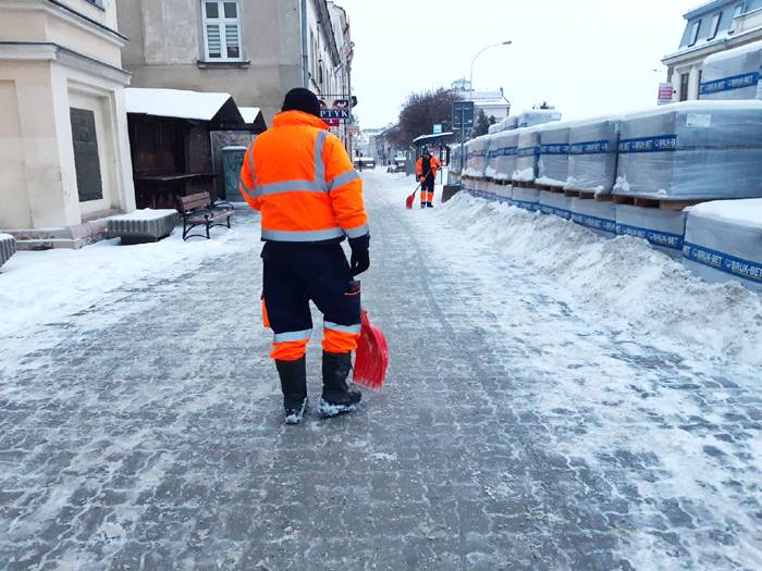 Pracownik PGKiM podczas odśnieżania chodnika.