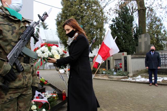 Dyrektor biura poselskiego Anny Schmidt składa wiązankę kwiatów przed tablicą poświęconą uczestnikom Powstania Styczniowego