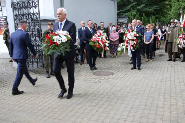 Marian Fedor, przewodniczący Rady Powiatu Jarosławskiego, składający wiązankę kwiatów po tablicą upamiętniającą zamordowanych.