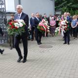 Marian Fedor, przewodniczący Rady Powiatu Jarosławskiego, składający wiązankę kwiatów po tablicą upamiętniającą zamordowanych.