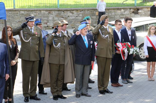 Przedstawiciele służb mundurowych podczas uroczystego momentu wciągnięcia flagi państwowej na maszt.