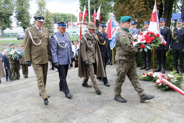 Składanie wiązanek kwiatów pod Pomnikiem Walk i Meczeństwa przez przedstawicieli służb mundurowych.