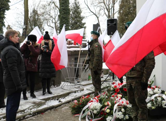 Składanie kwiatów pod tablicą pamięci