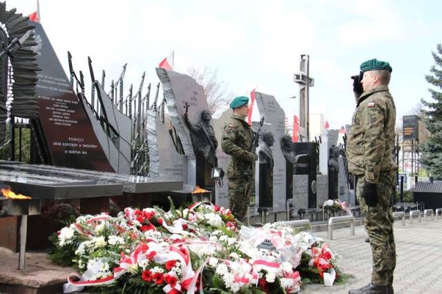 Pomnika Pamięci Narodowej udekorowany biało-czerwonymi wiązankami kwiatów. 